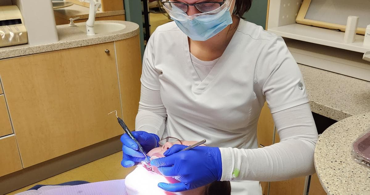 Dental assistant practicing coronal polishing